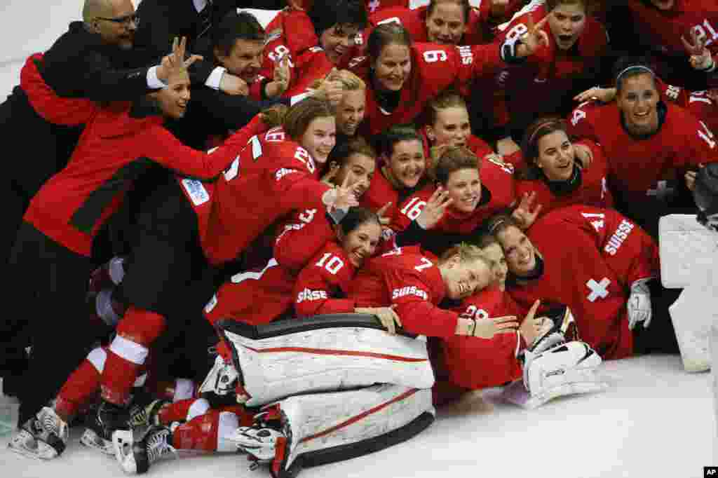Team Switzerland poses for a picture after their 4-3 win over Sweden in the women's bronze medal ice hockey game, Sochi, Feb. 20, 2014. 