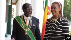 Zimbabwe President Robert Mugabe stands with his wife Grace, as they pose for a photo at State House in Harare, Oct, 28, 2014. 