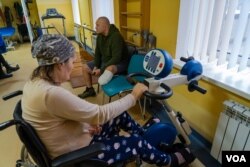 Andriy, de 44 años, sentado al fondo, dice que regresará al frente cuando pueda usar por completo su pierna ortopédica, en Lviv, Ucrania, el 16 de enero de 2023. [Foto: Yan Boechat,VOA]