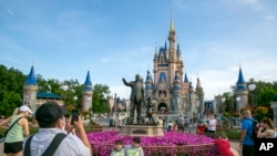 ARCHIVO - La gente visita el parque Magic Kingdom en Walt Disney World Resort en Lake Buena Vista, Florida, el 18 de abril de 2022.