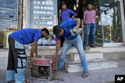 A shopkeeper starts a generator for electricity at a shop following a power breakdown across the country, in Karachi, Pakistan, Jan. 23, 2023.