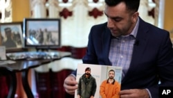 Sami-ullah Safi holds photographs of his brother, Abdul Wasi Safi, as he talks about his brother's journey to the U.S. during an interview in Houston, Jan. 18, 2023.