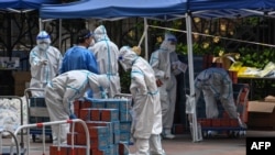 Workers wearing personal protective equipment (PPE) check food delivered by the local government for residents in a compound during a COVID-19 lockdown in the Jing'an district in Shanghai, China, April 10, 2022.