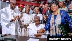Nigerian President Muhammadu Buhari signs an agreement during African Union summit in Niamey