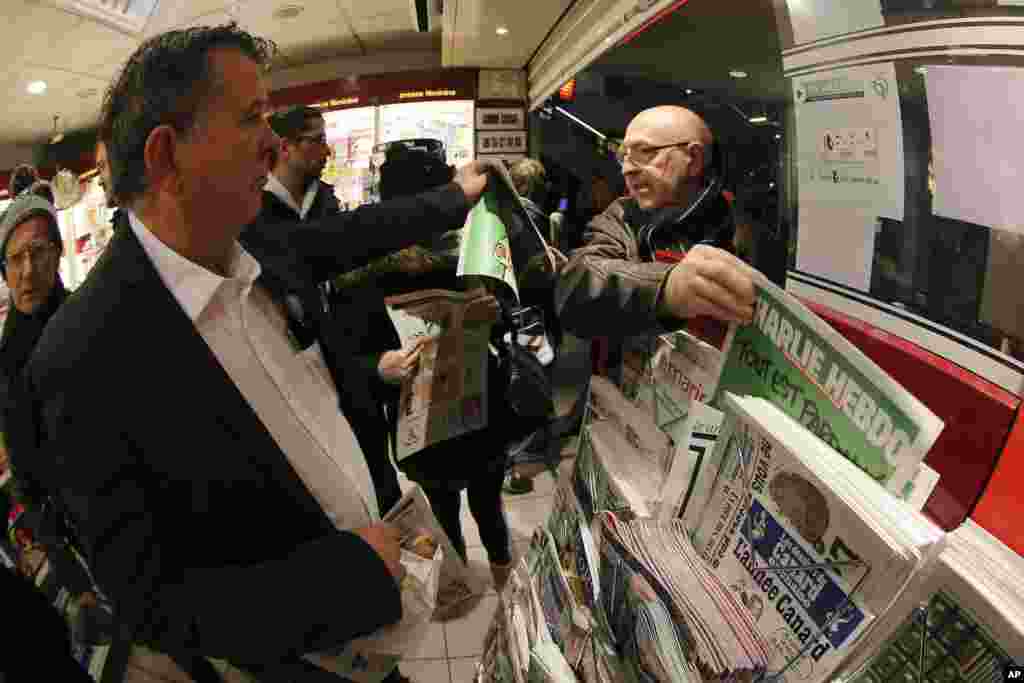 Warga mengambil tabloid Charlie Hebdo di kios koran di Rennes, selatan Perancis (14/1). (AP/David Vincent)