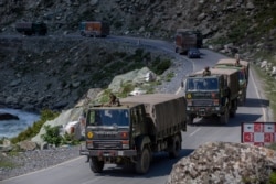 FILE - An Indian army convoy moves on the Srinagar-Ladakh highway at Gagangeer, northeast of Srinagar, Indian-controlled Kashmir, Sept. 9, 2020.