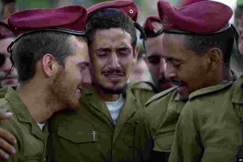 Isroillik askarlar halok bo'lgan safdoshlari qabri ustida ko'zyosh to'kmoqda, Holon, Isroil, 20-iyul, 2014-yil.