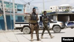 Des policiers montent la garde devant l'hôtel Hayat à Mogadiscio, attaqué samedi par les shebab.