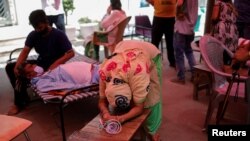 Wife of Nanhe Pal, 52, cries as she pleads for oxygen support for her husband, who is suffering from breathing problem at a Gurudwara (Sikh temple), amidst the spread of COVID-19, in Ghaziabad, India, May 3, 2021.