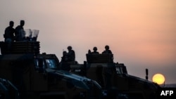 FILE - Turkish troops take position in the southeastern town of Suruc, Sanliurfa province, near the Mursitpinar border crossing with Syria, Oct. 3, 2014. 