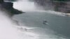 A ‘Maid of the Mist’ vessel sails past the American and Bridal Veil Falls, toward Horseshoe Falls, where poncho-suited tourists are often soaked by a thick mist. (R. Taylor/VOA)