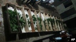 Puluhan jenazah yang ditemukan warga di Daraya, di luar ibukota Damaskus. Warga memakamkan para korban tewas hari Minggu (26/8).