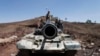 A frontal view of a tank barrel is seen as Shi'ite Houthi rebels stand on its turret, after they took over the compound of the army's First Armored Division in Sana'a, Yemen, Sept. 22, 2014. 