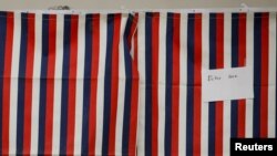A voter fills out a ballot inside a voting booth for New Hampshire's first-in-the-nation U.S. presidential primary election at the Stark volunteer fire dept. in Stark, New Hampshire, Feb. 11, 2020.