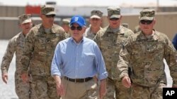 In this photo provided by ISAF Regional Command (South), U.S. Secretary of Defense Robert M. Gates walks with a group of service members at Forward Operating Base Waltman, Kandahar, Afghanistan, June 5, 2011