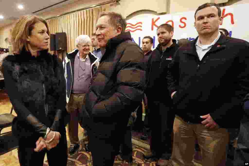 Kandidat capres dari Partai Republik Gubernur Ohio John Kasich, berbicara dengan istrinya Karen sebelum pertemuan terbuka terakhirnya di Manchester, N.H., 8 Februari 2016.