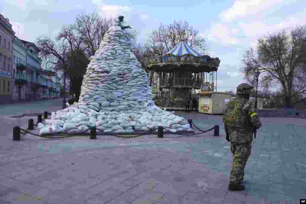 Ukrainian serviceman stands near to the monument of Duke de Richelieu, covered by sandbags to protect from possible damage, in Odessa, March 9, 2022.