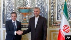 International Atomic Energy Organization, IAEA, Director General Rafael Mariano Grossi, left, and Iran's Foreign Minister Hossein Amirabdollahian shake hands prior to their meeting in Tehran, March 5, 2022.