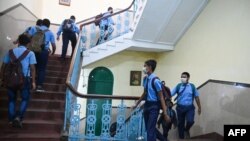 Niños caminan a sus respectivas aulas después de que las escuelas reanudaron las clases físicas que se cerraron antes para frenar la propagación del coronavirus en Calcuta, la India, el 3 de febrero de 2022.