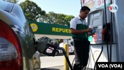 Un hombre que trabaja en una gasolinera en Managua llena el tanque de un vehículo Foto VOA.