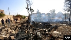 Warga Yaman menilai kerusakan menyusul serangan udara oleh koalisi pimpinan Saudi, menargetkan ibu kota pemberontak Houthi Sanaa, 26 Maret 2022. (MOHAMMED HUWAIS / AFP)