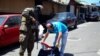 Un miembro del ejército revisa los documentos y pertenencias de un hombre en plena calle durante un patrullaje después de que el Congreso de El Salvador aprobara el domingo poderes de emergencia que suspendieron temporalmente algunas protecciones constitucionales.