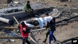 Voluntarios evacuan a un anciano residente en Irpín, a unos 25 kms (16 millas) al noroeste de Kiev, Ucrania, el 11 de marzo de 2022.