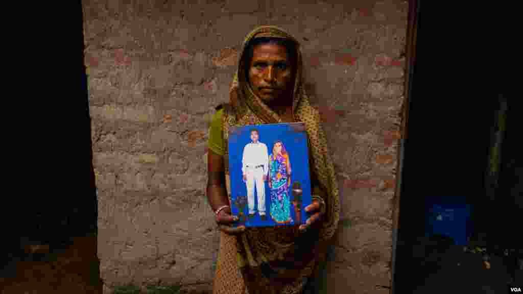 Aslan Devi Yadav, 41, shows a picture of her wedding day. Her husband, Muneshwar Yadav, worked on a construction site in Qatar and died a few months ago, pictured in the Dhanusha district of Nepal, August 2022 (Yan Boechat/VOA)