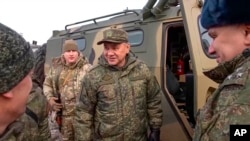 Foto tomada de un video del Servicio de Prensa del Ministerio de Defensa de Rusia el jueves 22 de diciembre de 2022. El ministro de Defensa ruso, Sergei Shoigu, en el centro, habla con los oficiales mientras inspecciona a las tropas rusas en un lugar no revelado en Ucrania. 