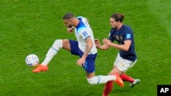 Kyle Walker de Inglaterra, a la izquierda, desafía el balón con Adrien Rabiot de Francia durante el partido de fútbol de cuartos de final de la Copa Mundial entre Inglaterra y Francia, en el estadio Al Bayt en Al Khor, Qatar, el sábado 10 de diciembre de 2022. (Foto AP/Hassan Ammar)