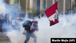 Un simpatizante del destituido presidente Pedro Castillo devuelve un contenedor de gas lacrimógeno en dirección a la policía, el 12 de diciembre de 2022, en Lima, Perú