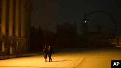 People walk in the snow in the city center of Kyiv, Ukraine, Nov. 18, 2022. 