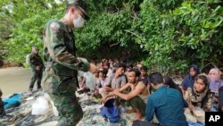 (မှတ်တမ်း ပုံဟောင်း) In this photo released by the Royal Thai Navy taken June 4, 2022, members of the Thai navy help Rohingya refugees found on Koh Dong Island in Satun province, southern Thailand.