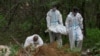 FILE - Forensic technicians carry the body of a person who, according to Ukrainian police, was killed and buried in an area ransacked by occupying Russian troops, near the village of Vorzel, Bucha district, Kyiv region, Ukraine June 13, 2022.