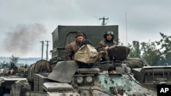 Kendaraan militer Ukraina bergerak di jalan di wilayah yang dibebaskan di wilayah Kharkiv, Ukraina, Senin, 12 September 2022. (AP/Kostiantyn Liberov).