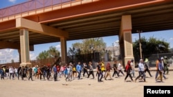 Migrantes, en su mayoría de Venezuela, caminan tras ser detenidos por agentes de la Patrulla Fronteriza de Estados Unidos, después de cruzar desde México para entregarse para solicitar asilo, en El Paso, EEUU, el 14 de septiembre de 2022.