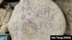 香港前商务及经济发展局局长邱腾华参观志记鎅木厂后签名留言“珍惜木材” (美国之音/汤惠芸)
