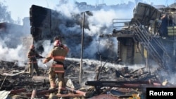 Vatrogasci gase požar u ostacima stambene zgrade unštene u ruskom raketnom napadu u naselju Zatoka, u regionu Odese, Ukrajina, 26. jula 2022. (Foto: Reuters/Press service of the State Emergency Service of Ukraine/Handout)