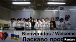 Alumnos y profesores posan para una foto después del segundo día del curso para refugiados ucranianos como parte de un programa de formación del gobierno regional de Valencia para integrar a los refugiados y permitirles comenzar una vida laboral activa en el sector del turismo y la hostelería, en Alicante, España. 21 de abril de 2022. REUTERS/Eva Manez
