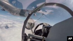 En esta imagen tomada de un video, efectivos de la fuerza aérea y la aviación de la Armada del del Ejército Popular de Liberación realizan una operación de repostaje en pleno vuelo en China, el 4 de agosto de 2022. (Xinhua vía AP)