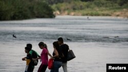 Solicitantes de asilo cruzan el río Grande, desde México a Estados Unidos, el 13 de julio de 2022.