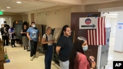 California voters wait in line to cast their ballots in the primary election minutes before the ballots close in the Echo Park Recreation Center in Los Angeles, June 7, 2022.