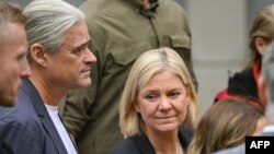 Swedish Prime Minister Magdalena Andersson and her husband, Richard Friberg, arrive to cast their votes at a polling center in Nacka, near Stockholm on September 11, 2022, during Sweden's general elections. 