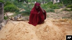 Fatuma Abdi Aliyow se lamenta junto a las tumbas de sus dos hijos muertos por enfermedades relacionadas con la desnutrición, en un campamento para desplazados, el 3 de septiembre de 2022, en las afueras de Mogadiscio, Somalia. 