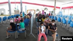 Los niños esperan que se les administre la vacuna de Pfizer contra la enfermedad del coronavirus en un complejo deportivo, en Lima, Perú, el 24 de enero de 2022.