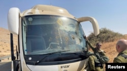 سربازان اسرائیلی در کنار اتوبوسی که از سوی دو ضارب فلسطینی هدف تیراندازی قرار گرفت. دره اردن در کرانه باختری. ۴ سپتامبر ٢٠٢٢