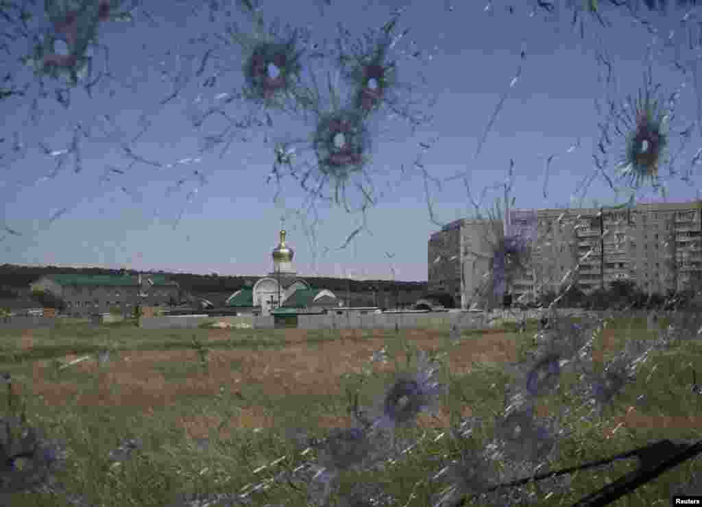 A Ukrainian border post is seen through bullet holes in a truck's windscreen on the outskirts of the eastern Ukrainian city of Luhansk, June 3, 2014.