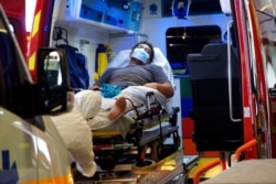 FILE - A man lies in an ambulance at a hospital in Papeete, Tahiti, French Polynesia, Aug. 20, 2021. France's worst virus outbreak so far is unfolding 12 times zones away from Paris, devastating the idyllic atolls of French Polynesia.