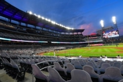 FILE - Cardboard cutouts of fans in the otherwise empty seats at Truist Park face the field during the sixth inning of a game between Atlanta and visiting Tampa Bay, July 30, 2020.