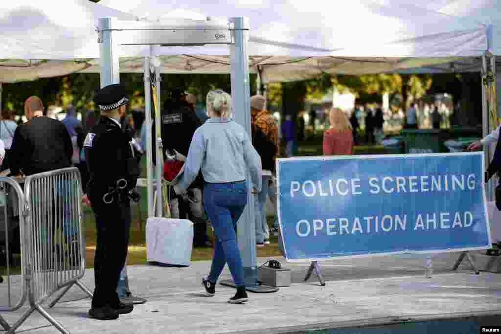 A woman walks by a police security check on arriving at The Long Walk, following the death of Britain's Queen Elizabeth, in Windsor, Britain, Sept. 18, 2022.